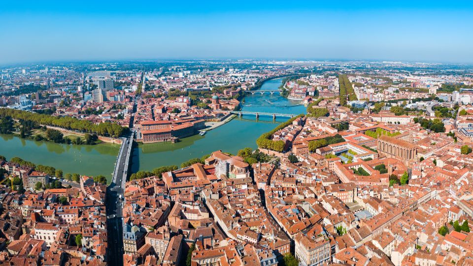 Vue aérienne de Toulouse montrant la Garonne et plusieurs ponts.